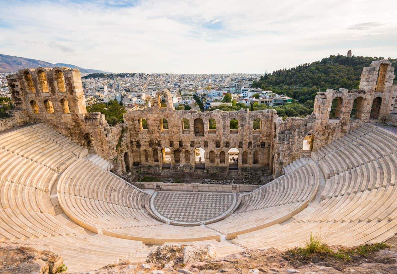 An aerial view of the Odeon Herodes Atticus in Greece, with a view of Athens in the background.