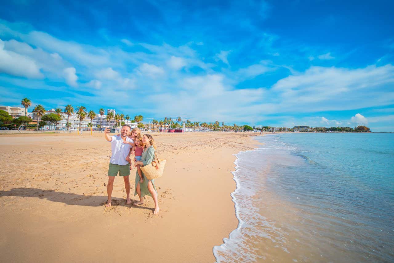 Una familia haciéndose un selfie en la playa de Cambrils
