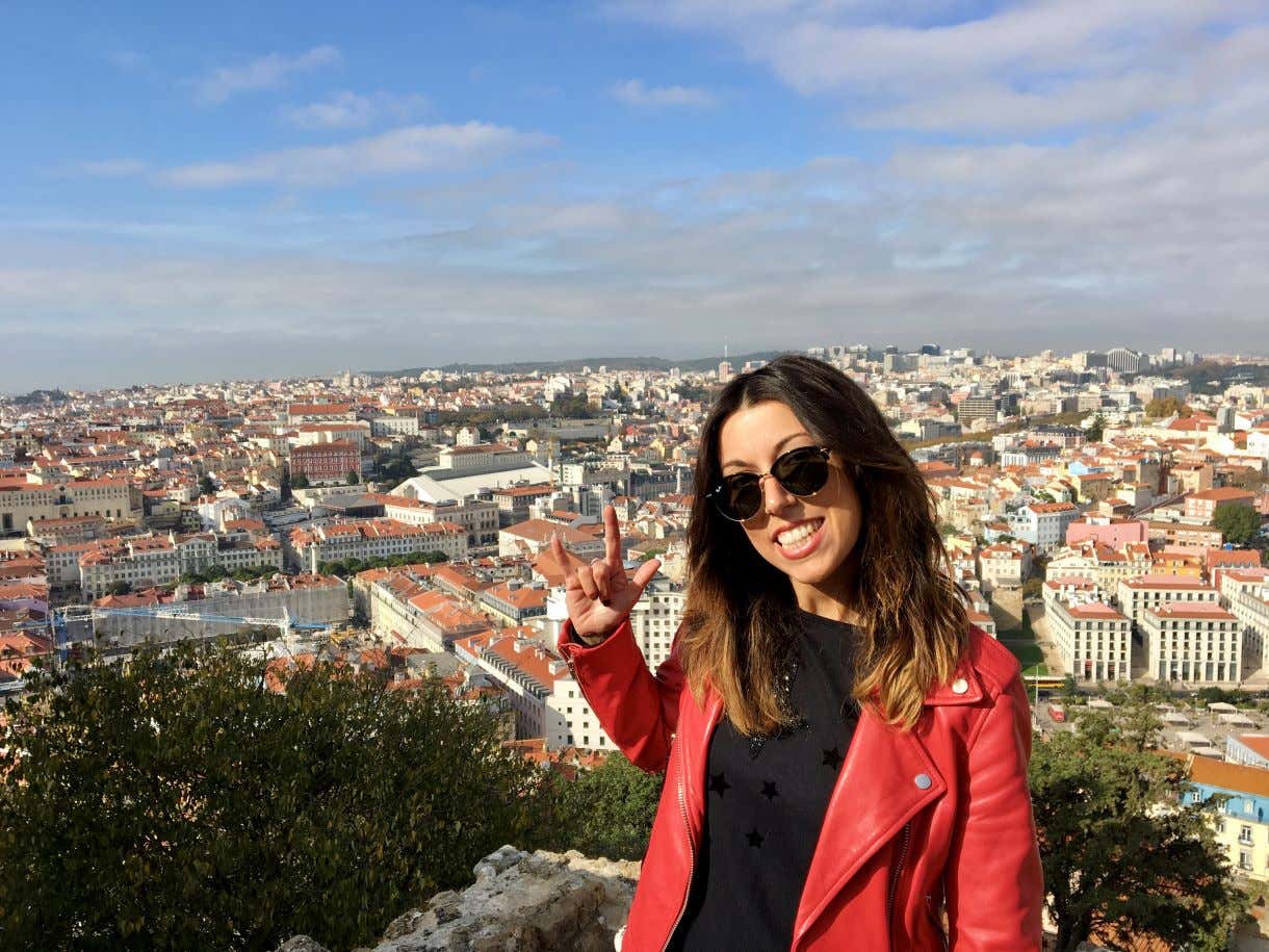 Laura sonriendo sobre una vista panorámica de una ciudad europea