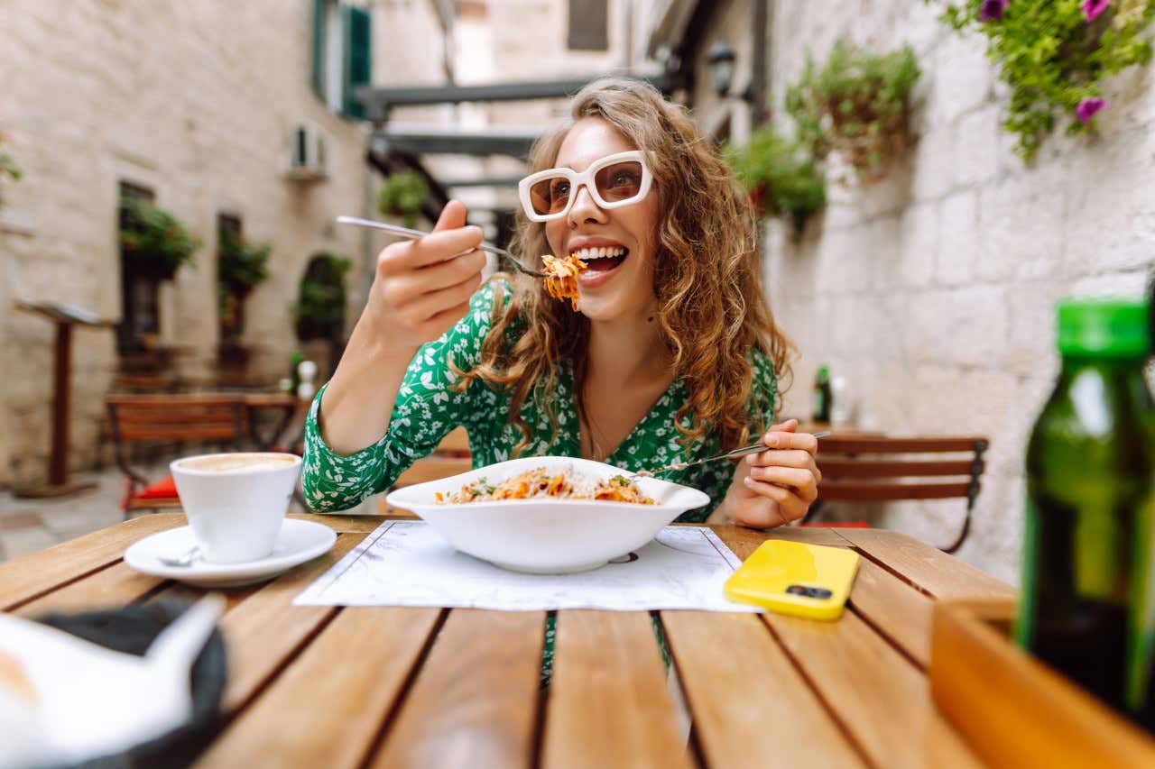 Mujer comiendo pasta de un plato de espaguetis