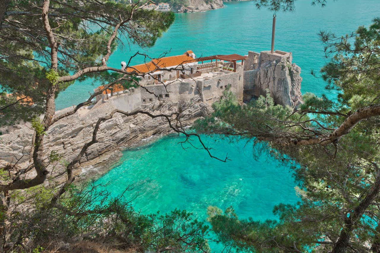 Scorcio dall'alto di un piccolo promontorio roccioso affacciata su un mare di un colore turchese molto intenso