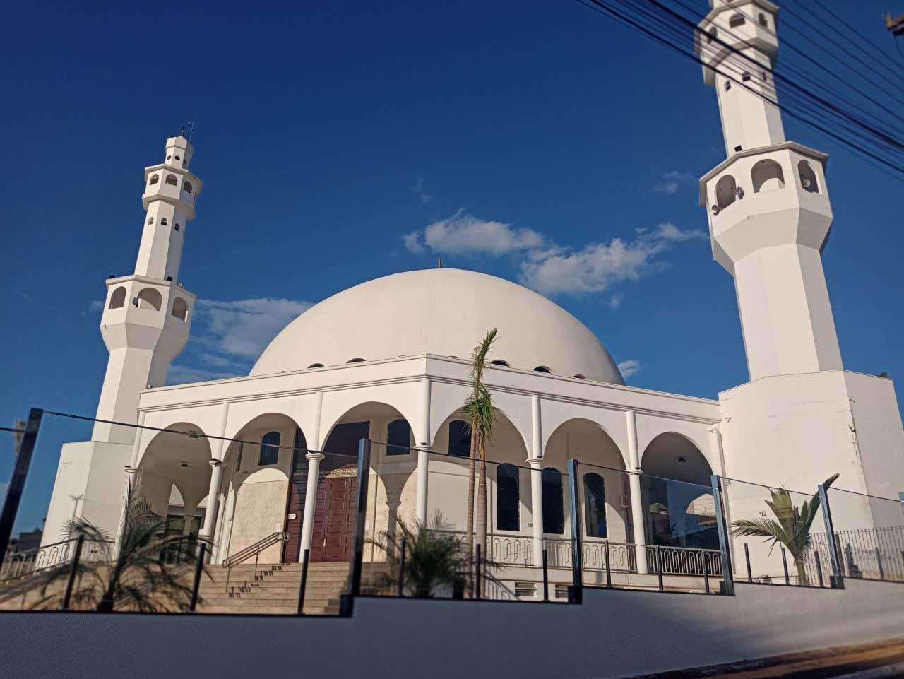 Uma mesquita branca com dois miranetes ao lado e uma grande cúpula