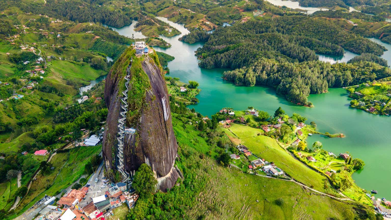 Vista panoramica su El Peñón de Guatapé, un'imponente formazione rocciosa circondata da una natura verde e rigogliosa e un fiume