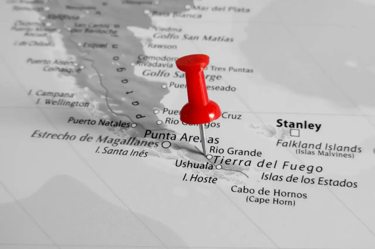 Detalhe do mapa da Patagônia com um alfinete vermelho afixado na altura da Terra do Fogo
