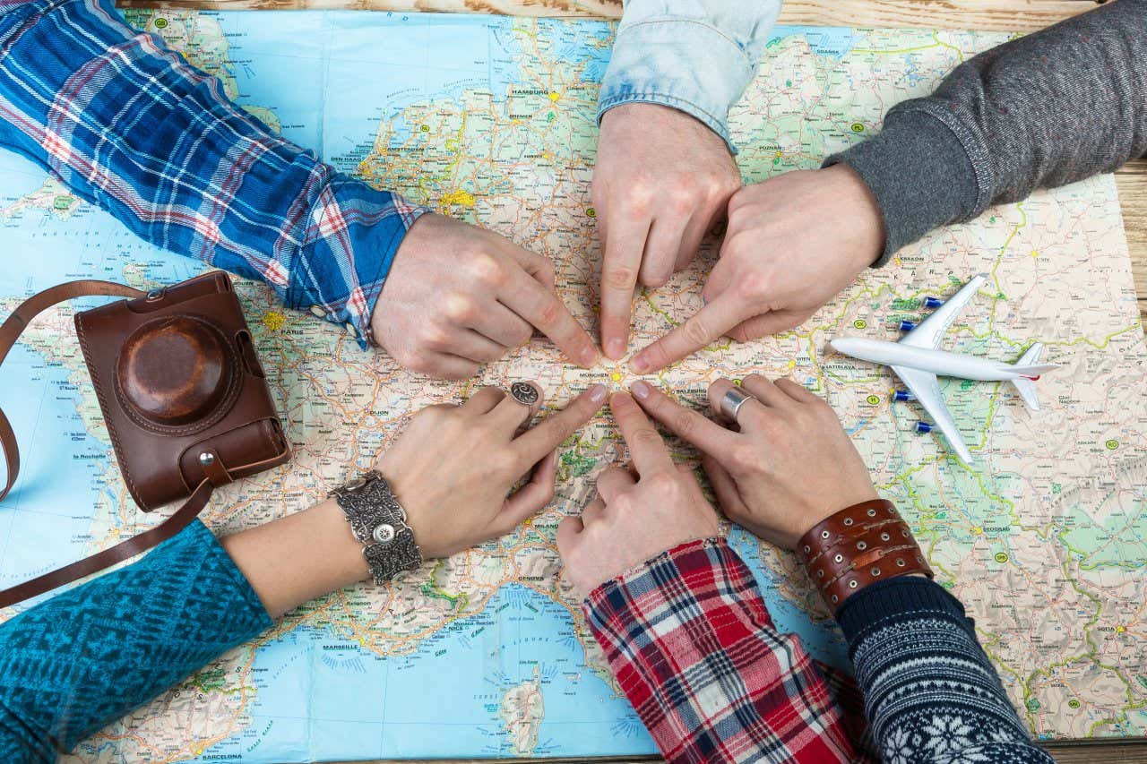 Una mappa con al centro diverse mani che indicano un punto
