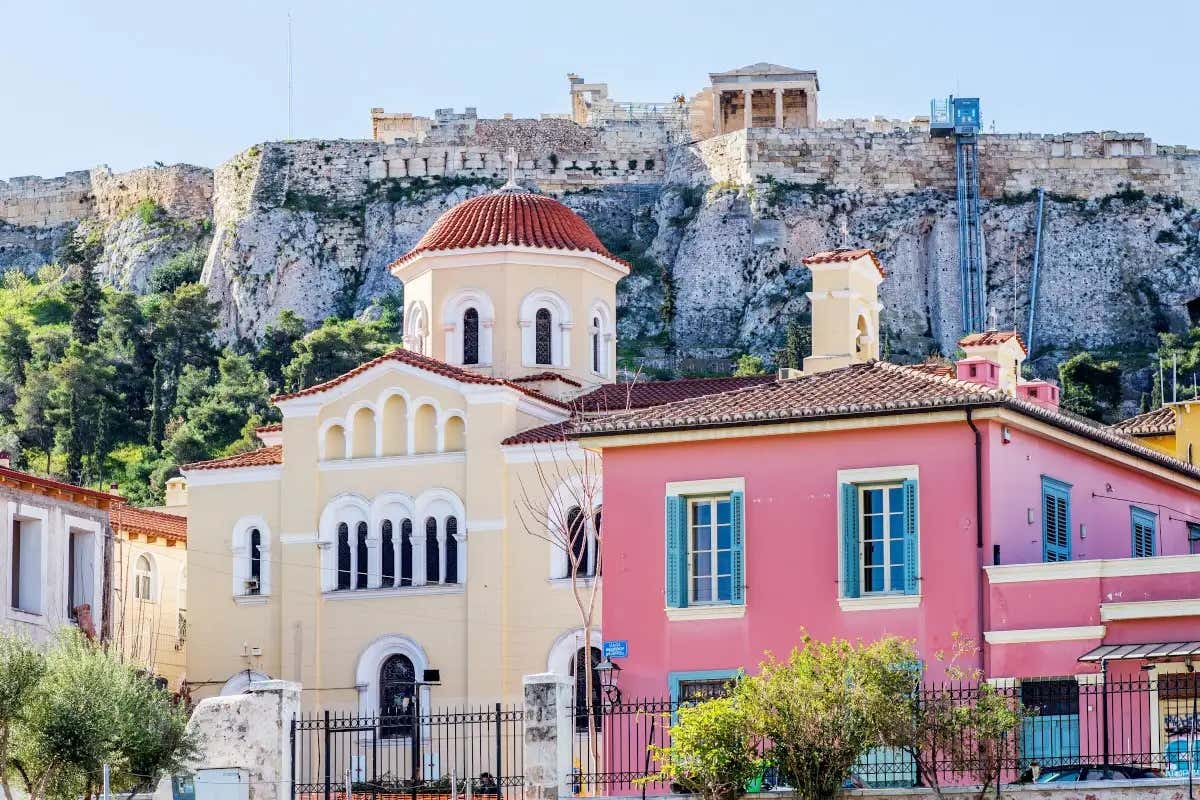 Casas atenienses com ruínas de um sítio arqueológico ao fundo