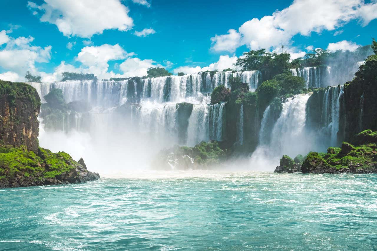 Cascades d'eau entourées de végétation sous un ciel bleu et quelques nuages, l'un des plus beaux parcs du monde