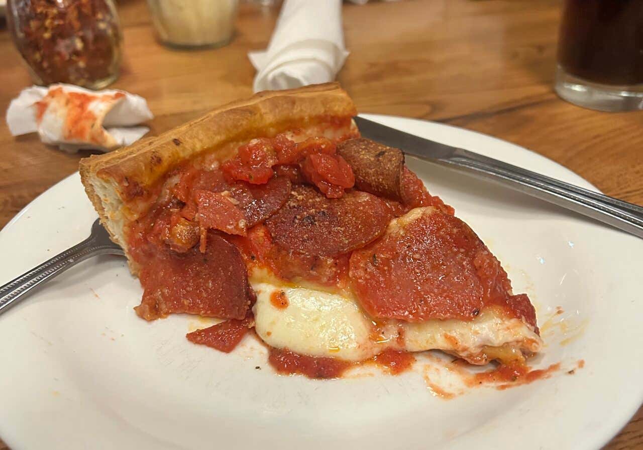 Detalhe de um pedaço de pizza em um prato branco