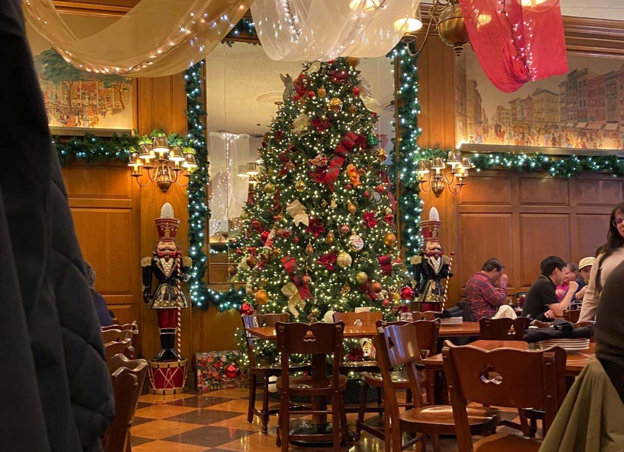 Uma árvore de Natal com algumas pessoas ao redor sentadas