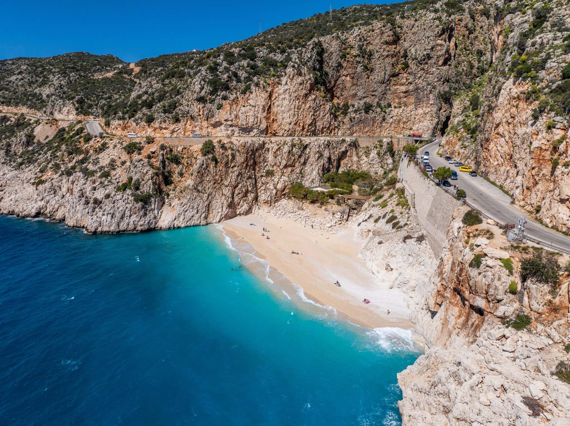 Una veduta aerea della spiaggia di Kaputas, con una strada visibile sulle scogliere sovrastanti.