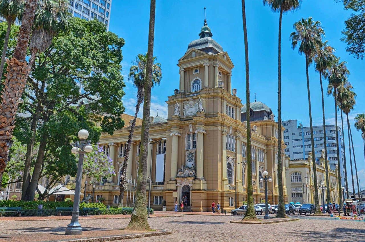 Edifício colonial do MARGS localizado ao lado de uma praça com chão de paralelepípedos