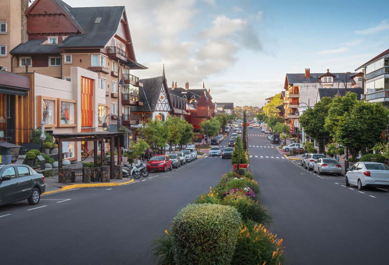Vista da cidade de Gramado, no Rio Grande do Sul, com algumas casas, carros e plantas em um dia ensolarado