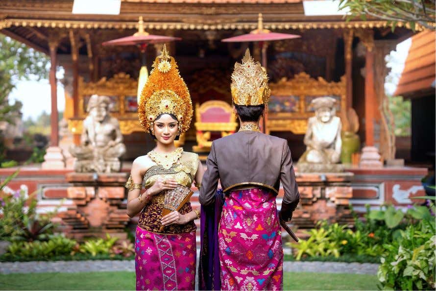 Pareja con vestimenta balinesa en frente de un templo en Bali