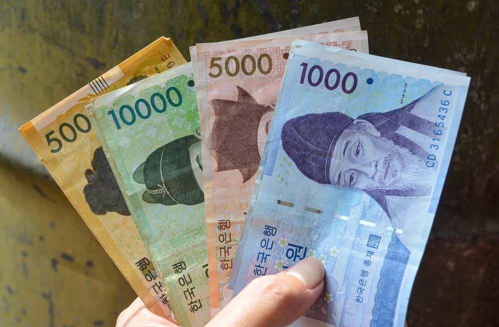 Una mano tiene 4 tipi di banconote coreane di diverso valore e colore
