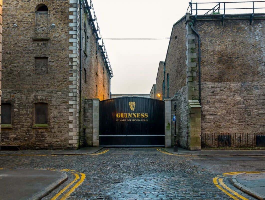 Fachada de um portão preto da The Guinness Storehouse em uma rua deserta