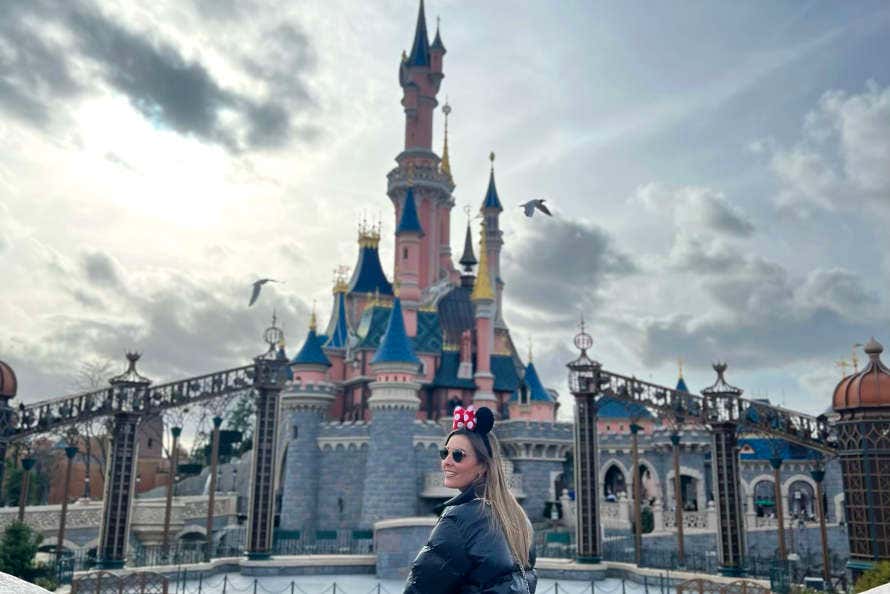 Irene con unas orejas de Minnie ante el castillo de Disneyland Paría