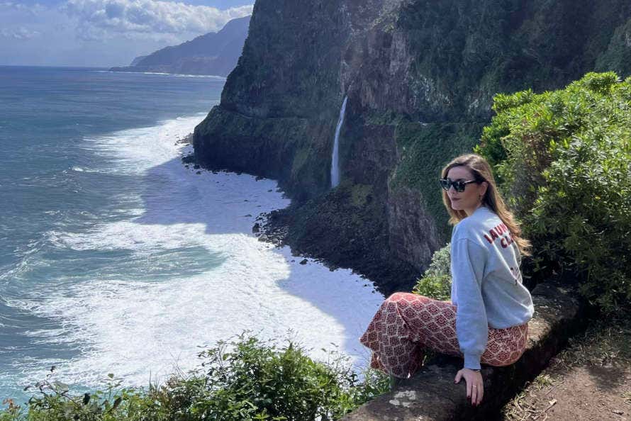 Irene sentada en un acantilado de la costa de Madeira
