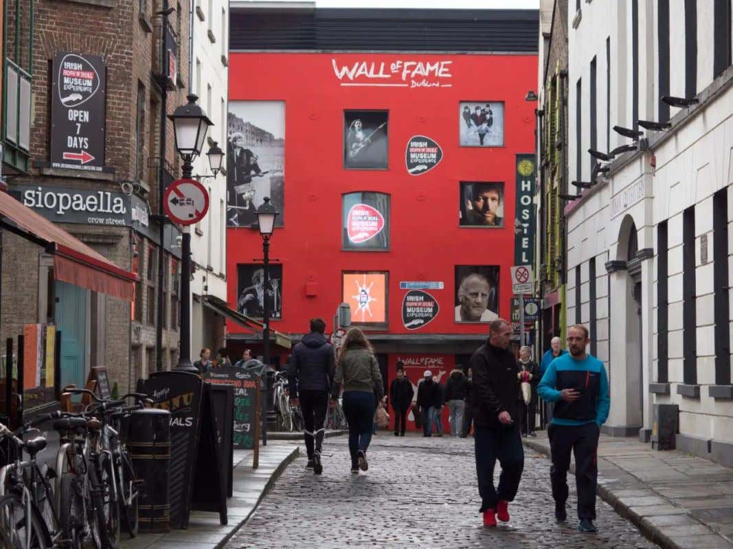 Algumas pessoas caminhando por uma rua de Dublin, perto do The Rock ‘n’ Roll Museum