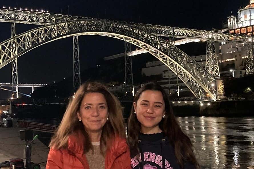 Ana Gallego y su hija frente a un puente en Oporto en la noche