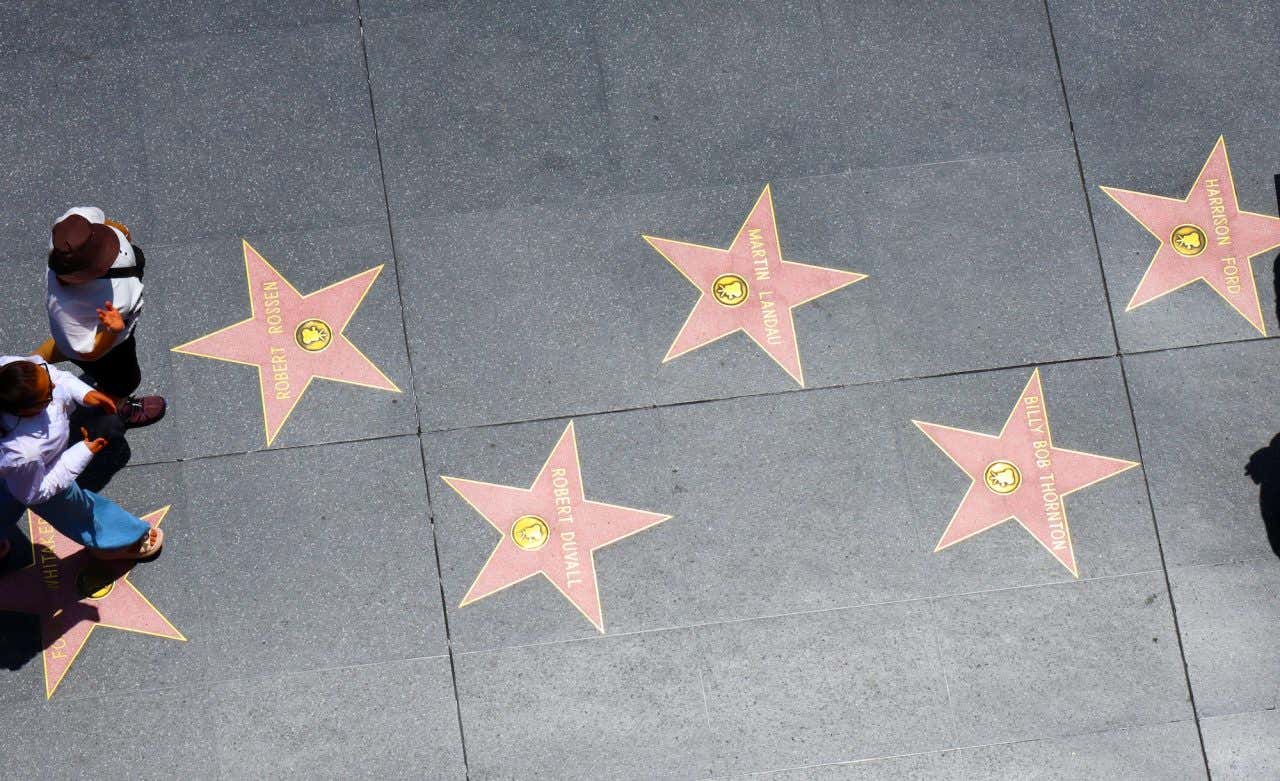 Due persone viste dall'alto camminano lungo la Walk of Fame di Hollywood, nella lista di cosa vedere a Los Angeles