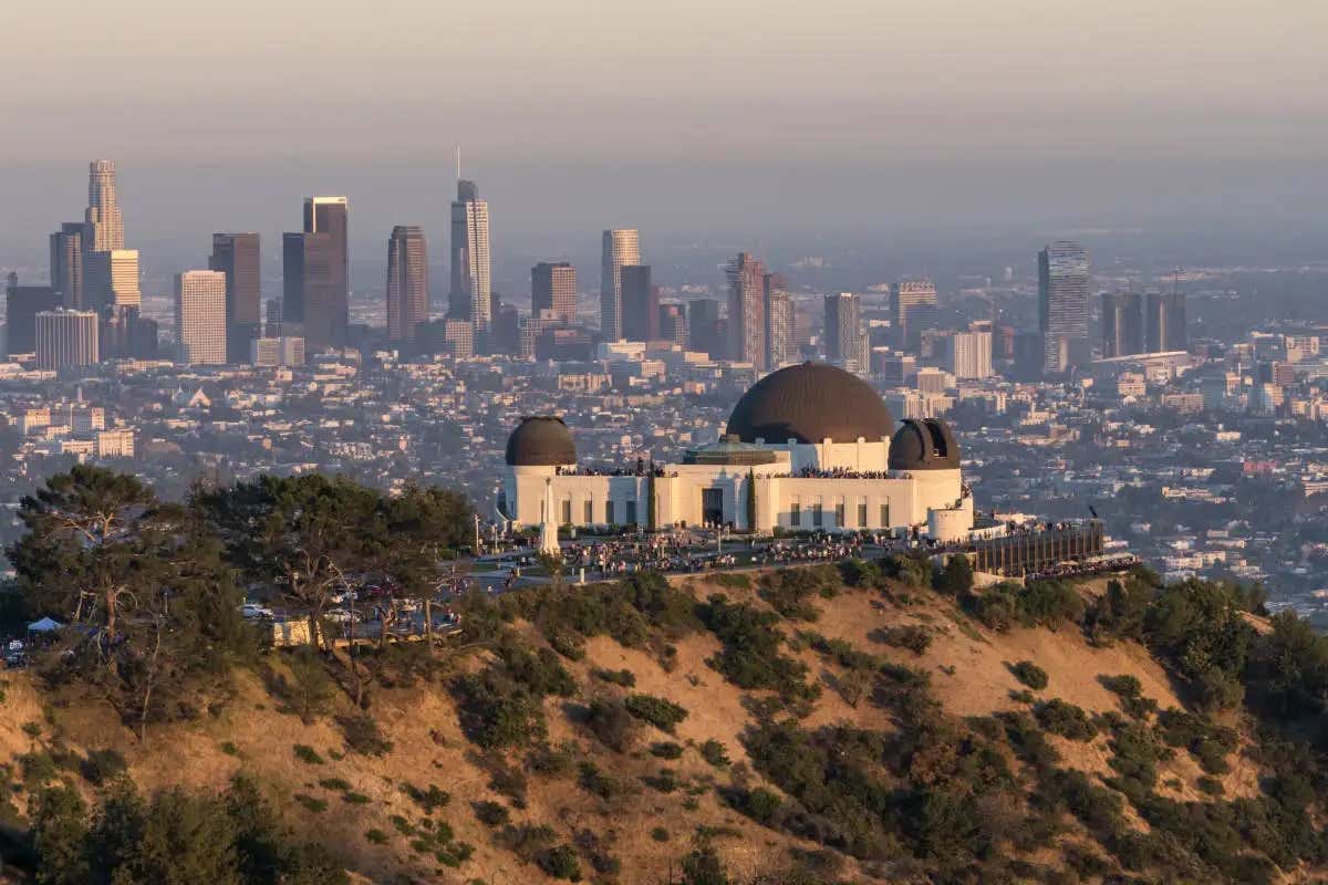 Vista aérea do Griffith Observatory em cima de uma colina com Los Angeles ao fundo