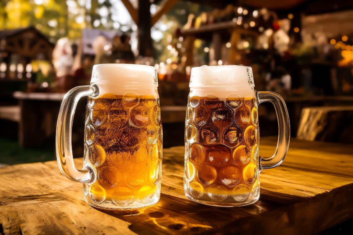 Dos jarras de cerveza rubia alemana sobre una mesa de madera