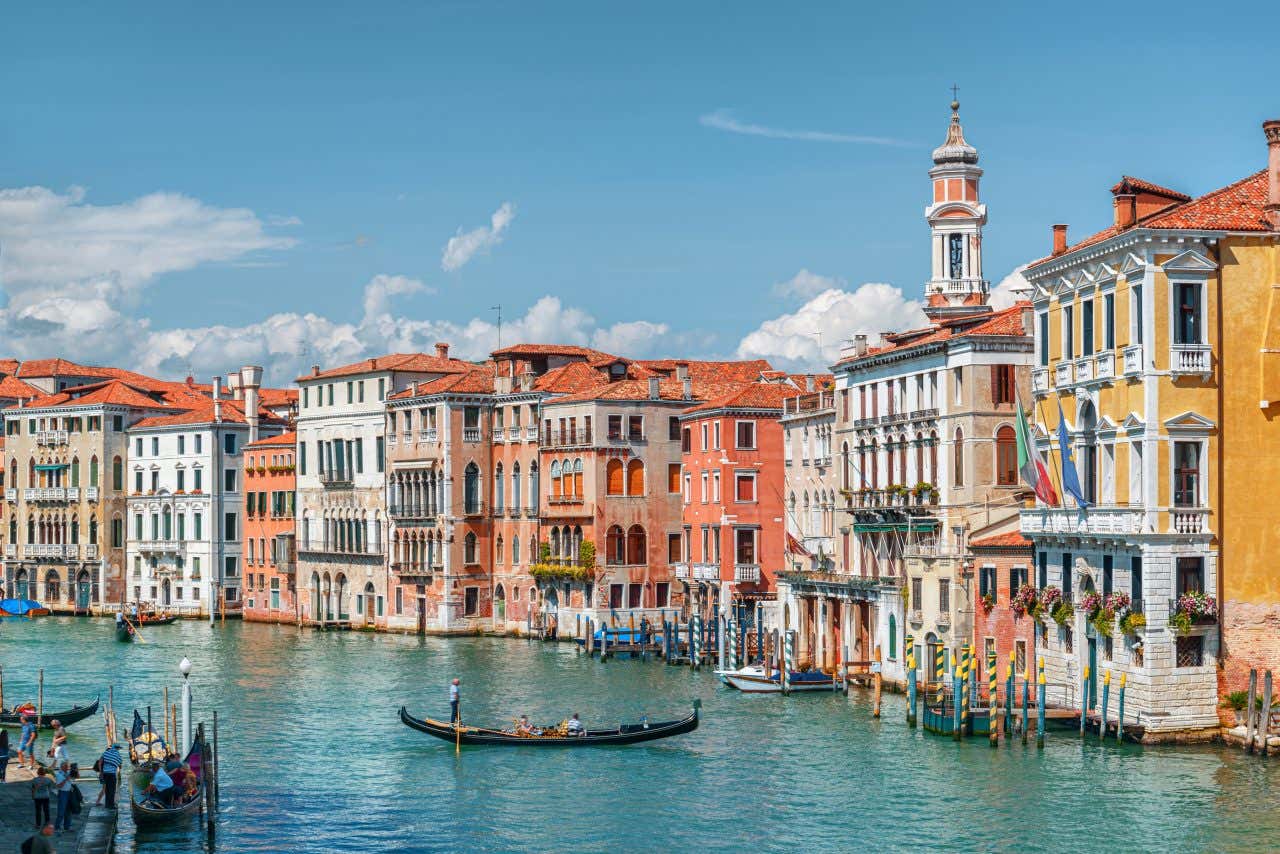 The city of Venice with colorful buildings and a boat in its canals on a sunny day