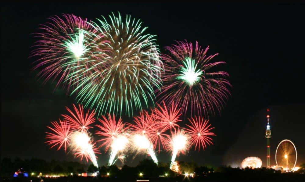 Feu d'artifices colorés dans un ciel noir au-dessus d'une ville