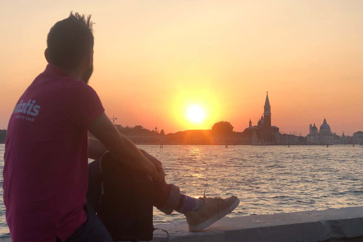 Un hombre de espaldas contemplando el atardecer en Venecia