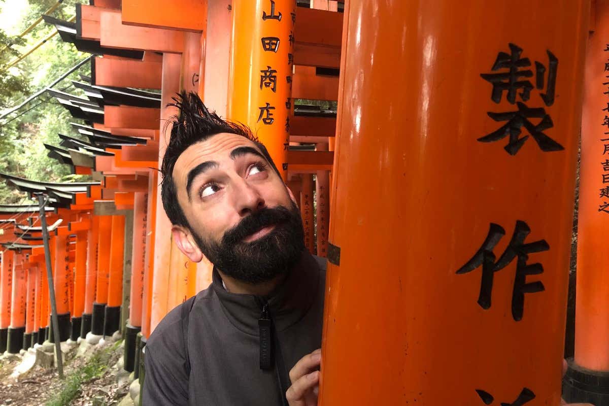 Un hombre visitando un templo con letras japonesas