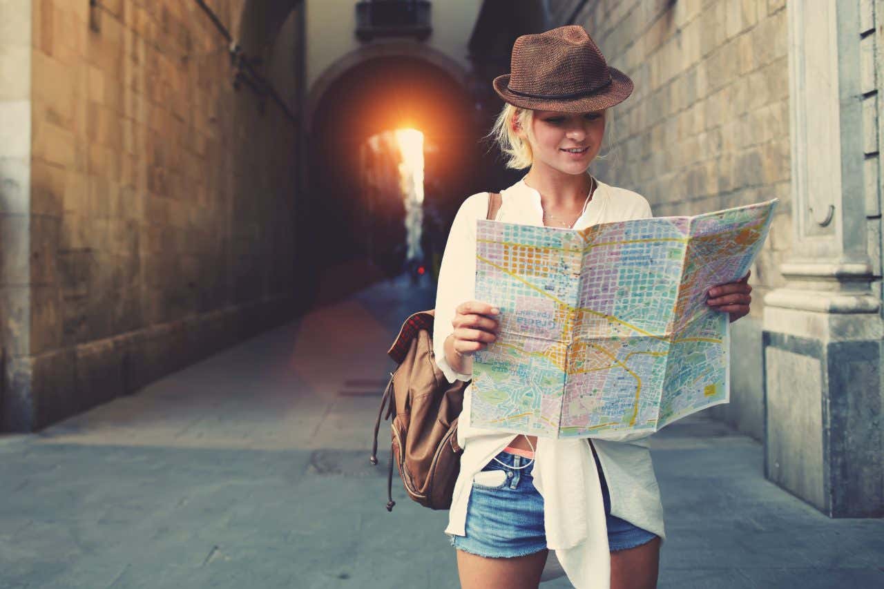 Jeune femme regardant une carte dans une rue