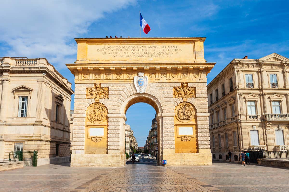Detalle del Arco del Triunfo de Montpellier, decorado con tonos ocres y amarillos y una bandera francesa en su parte superior
