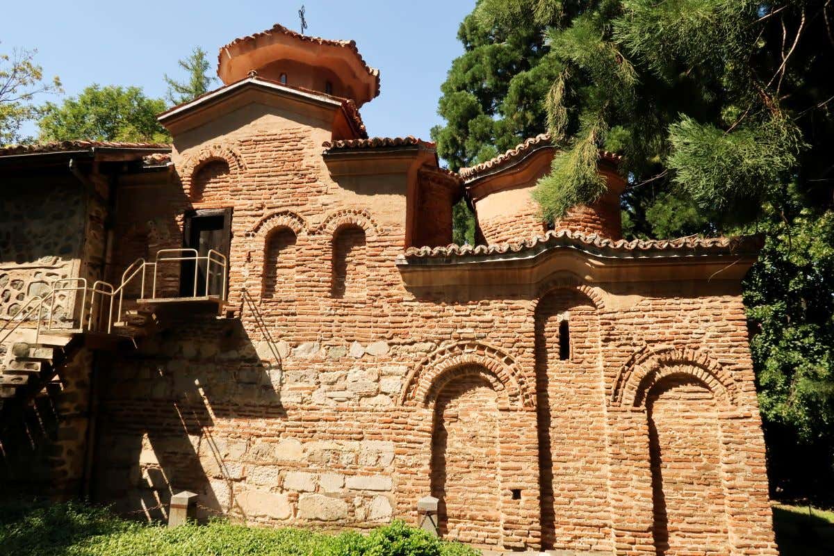 Una iglesia en ladrillo y piedra en Sofía rodeada de arboleda