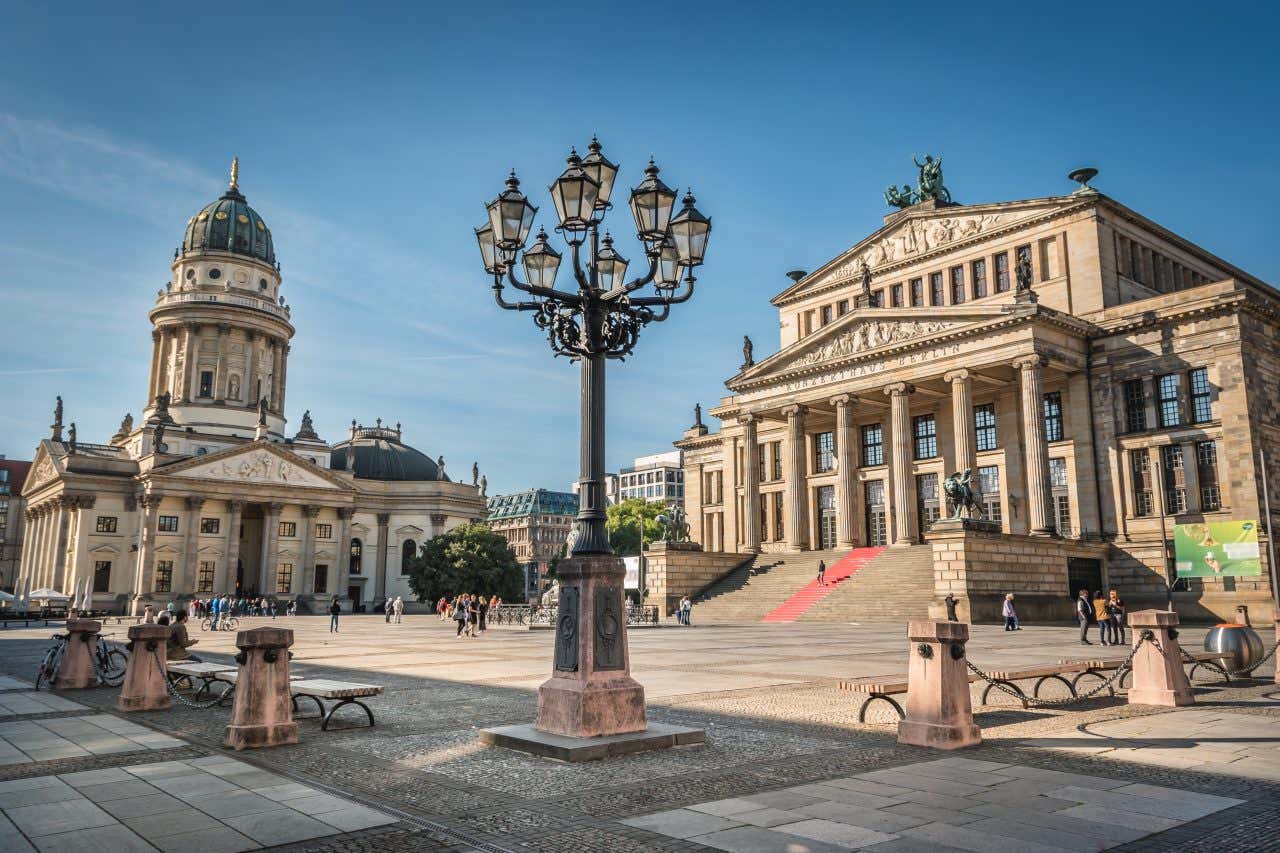 La place de Gendarmenmarkt avec un lampadaire au premier plan et deux bâtiments imposants sous un ciel dégagé