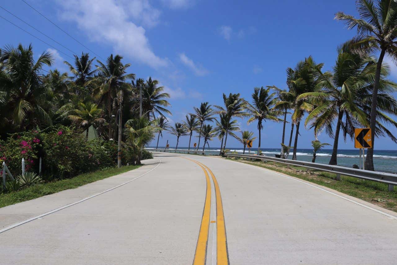Uma estrada simples rodeada de vegetação com vista ao mar de San Andrés