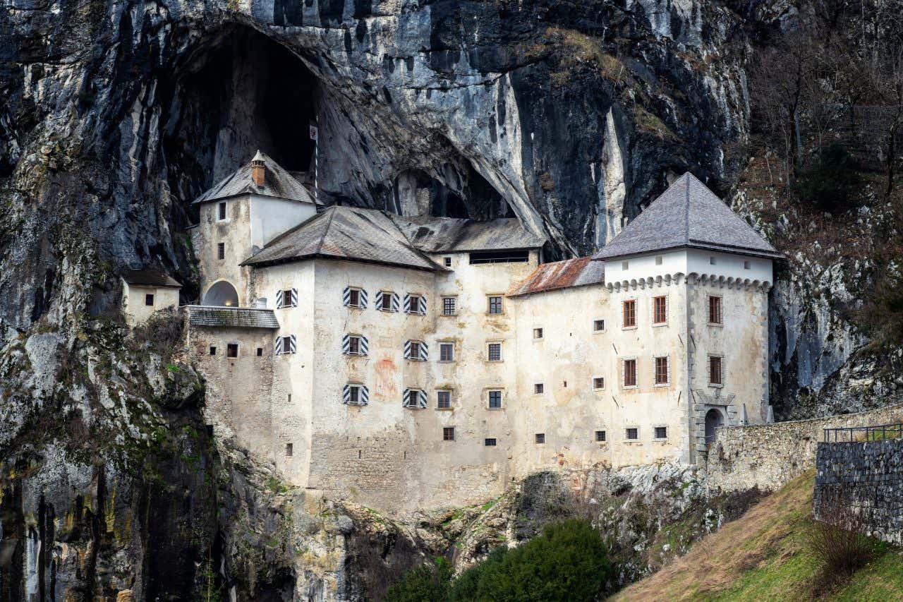 Il castello di Predjama incastonato tra le rocce scure di un dirupo, all'imboccatura di una grotta naturale