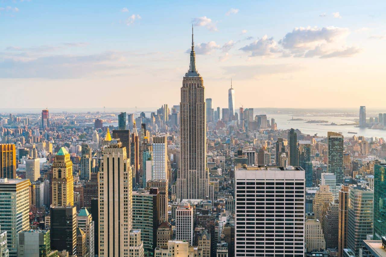 Panoramic view of New York skyline with the Empire State Building in the middle as the sun is rising.
