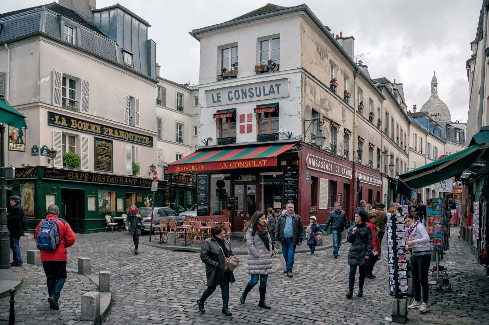Una fachada de tienda con un cartel que dice 'LE CONSULAT' en las calles de Montmartre