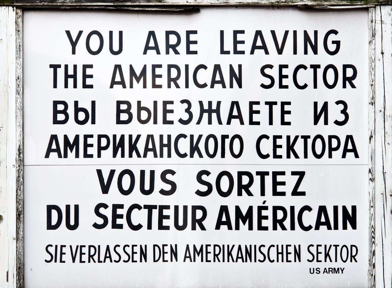 Pancarte historique de Checkpoint Charlie indiquant la sortie du secteur américain, une visite à faire absolument à Berlin