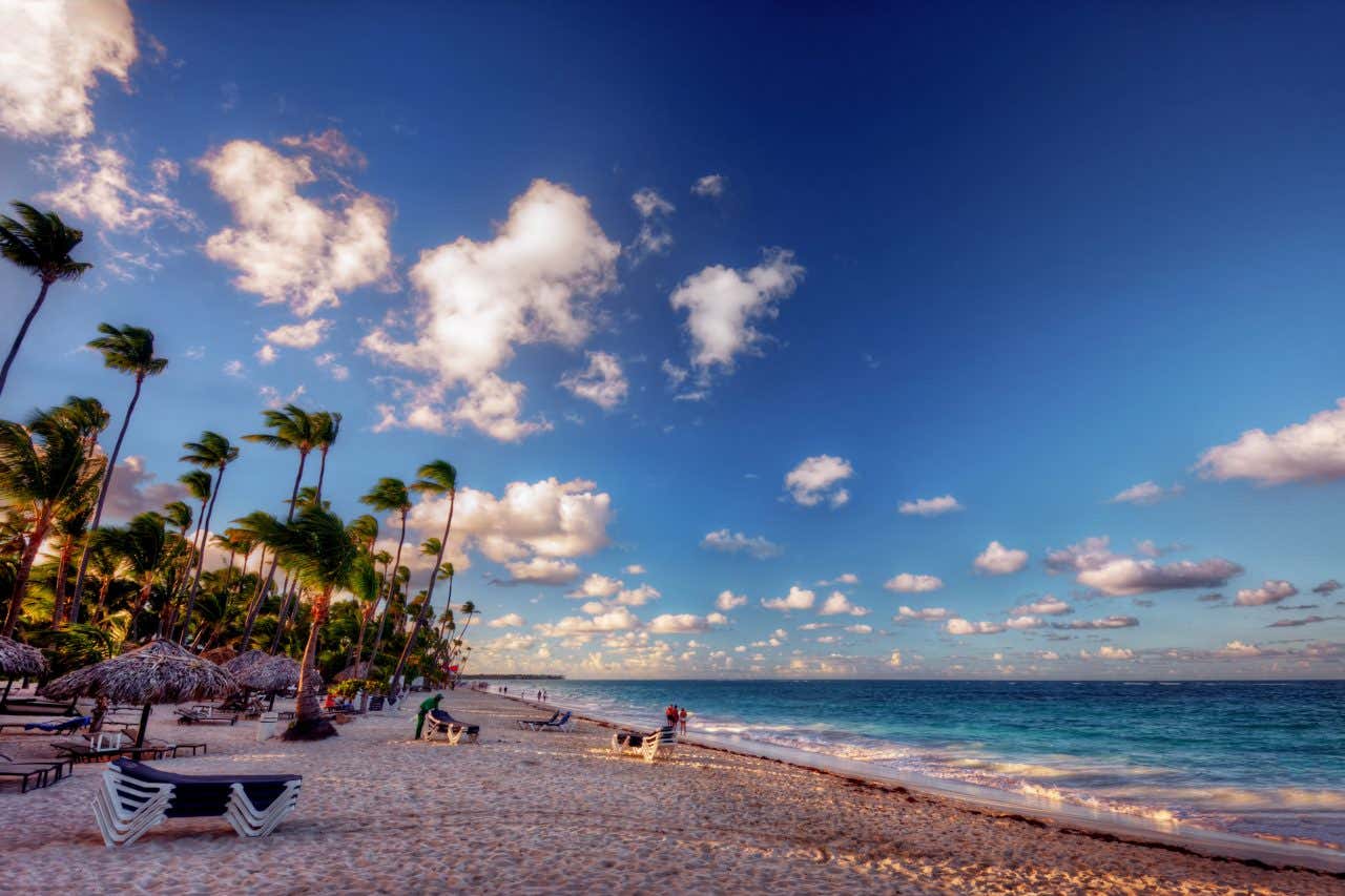 A golden beach with a cloudy blue sky in the background.