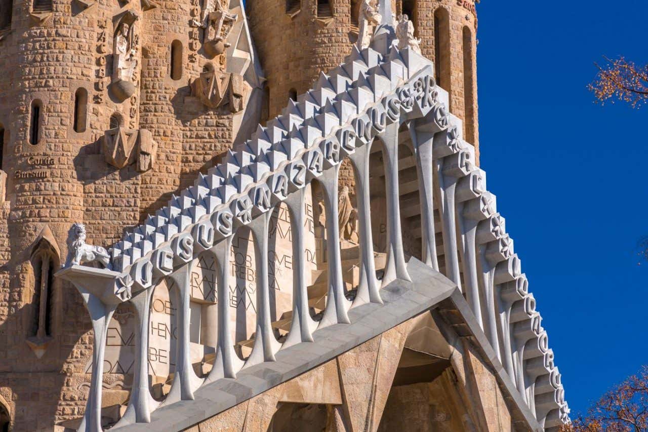 Detalles ornamentados en piedra marrón y blanca en la fachada de la Sagrada Familia