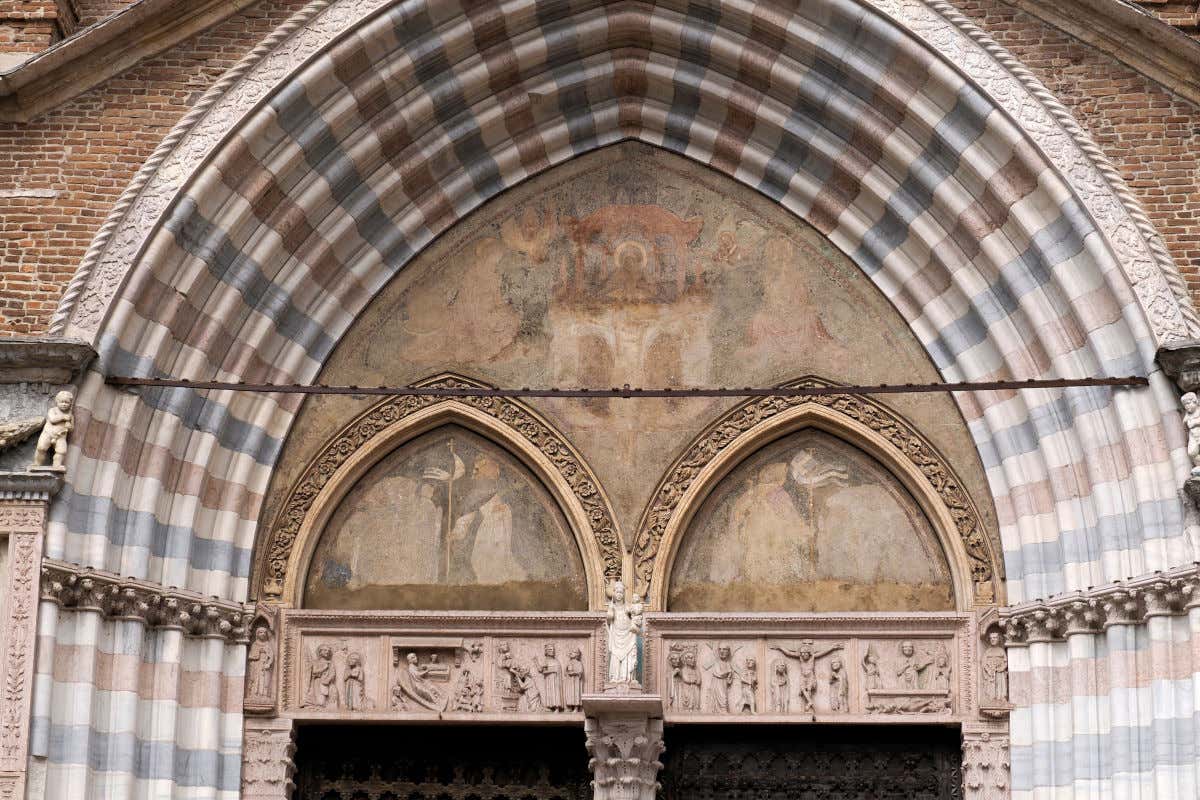Pórtico, dividido con dos puertas, en una iglesia decorada con varias columnas y mosaicos
