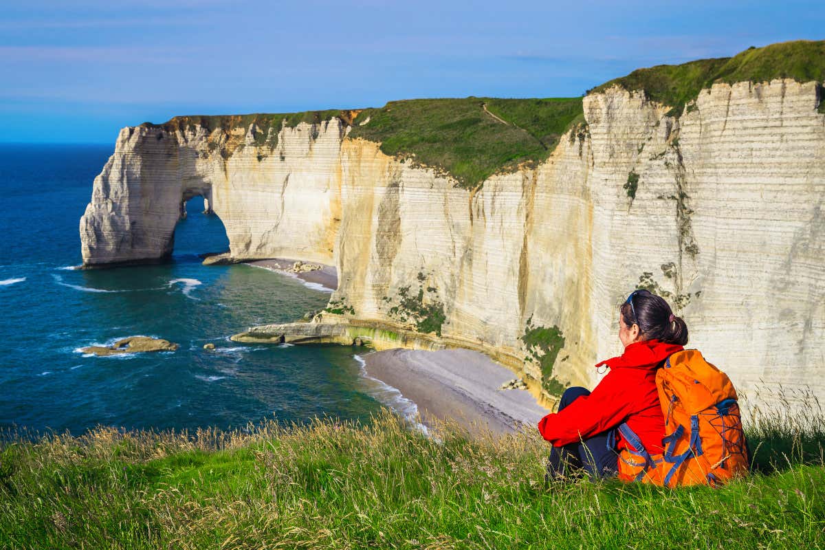 Una mujer contemplando los acantilados de Étretat, en Francia