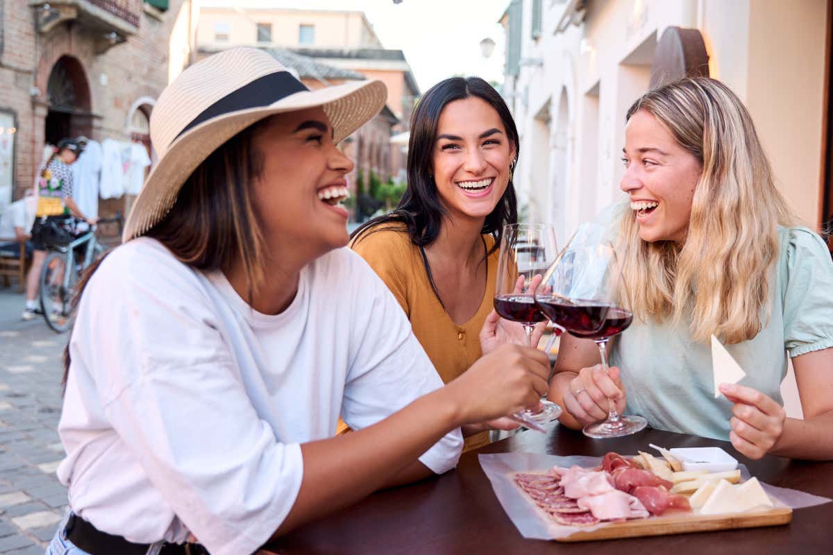Un grupo de amigas disfrutando de unas copas de vino tinto