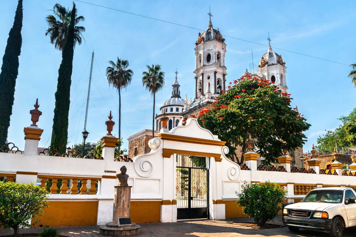Santuario de Nuestra Señora de la Soledad, un templo de grandes dimensiones con dos torres y una cúpula rodeado de árboles y de un muro blanco y naranja