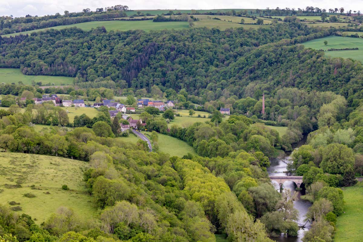 Vista aérea de un valle verde, un río y un pueblo en la denominada Suiza normanda