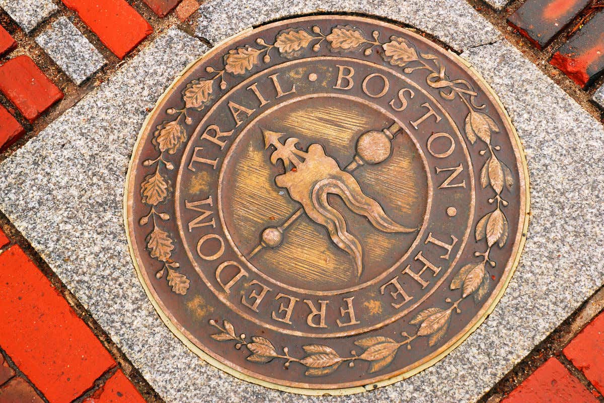 Una placa ubicada en el suelo con indicaciones de la ruta Freedom Trail de Boston