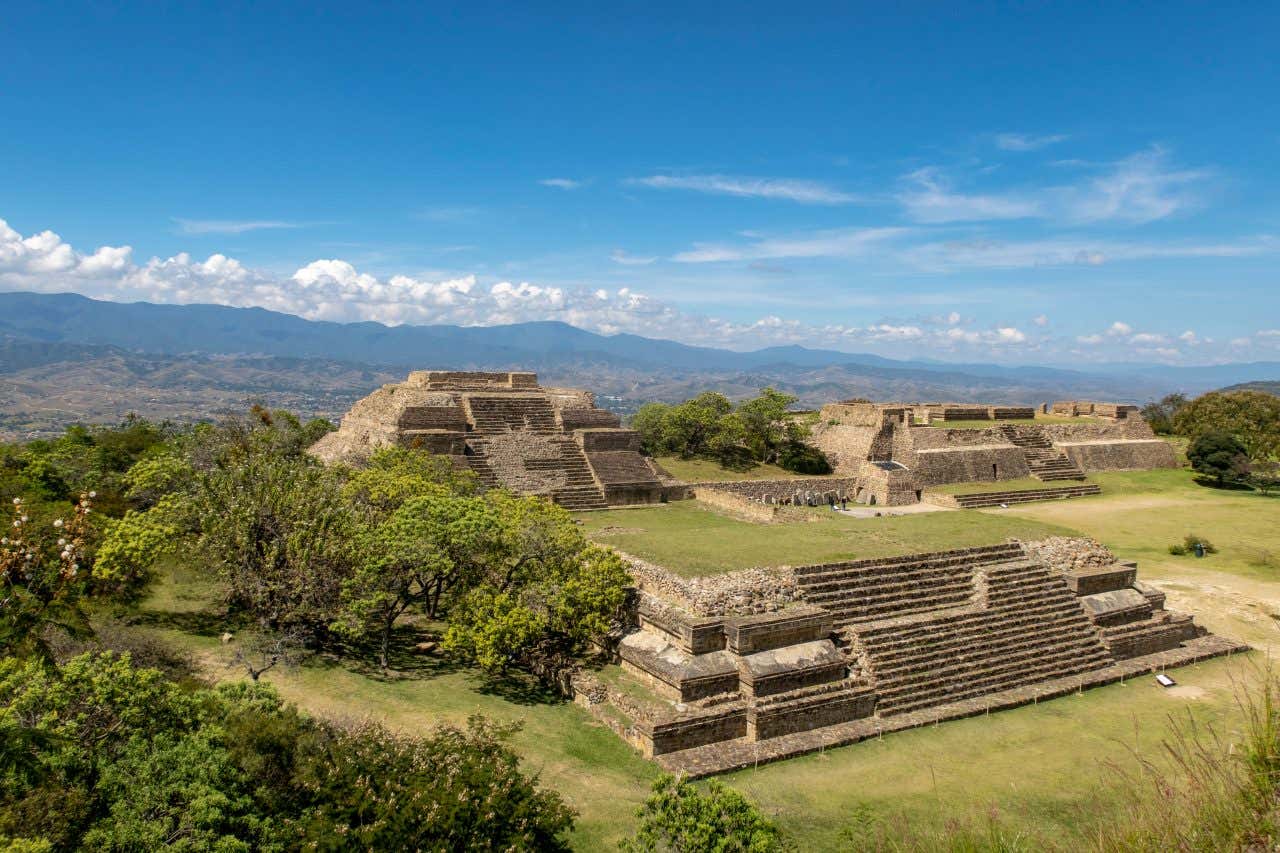 Monte Albán as seen from above with a cloudy blue sky in the background.