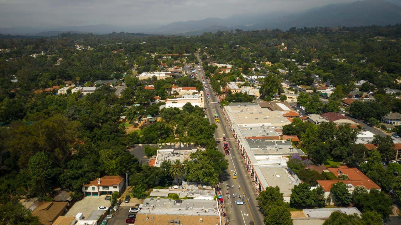 Ojai town seen from above duringa parade with a cloudy sky in the background.