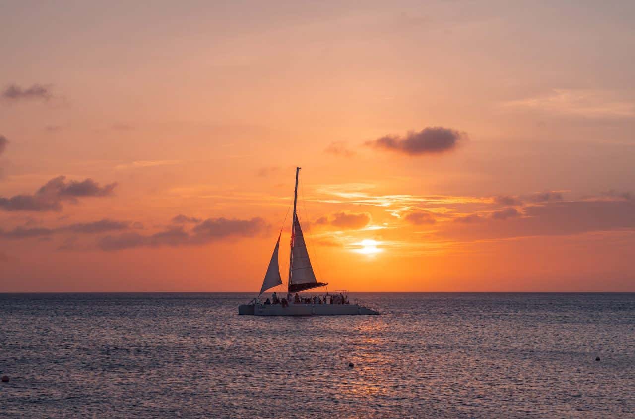 Um catamarã navegando ao entardecer